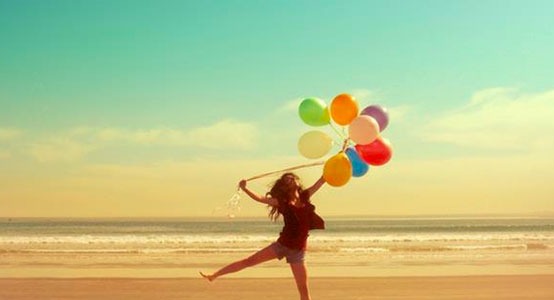 girl with balloons in the beach