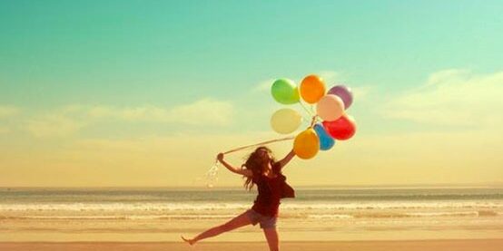 girl with balloons in the beach